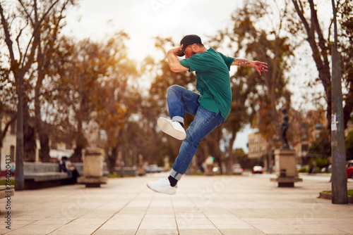 latin American breakdancer performing foot movements or toprock in the air on the street 