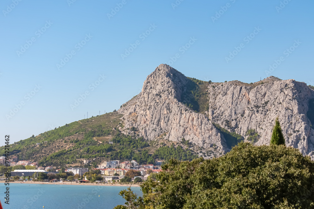 Scenic view of coastal town Omis surrounded by Dinara mountains in Split-Dalmatia, South Croatia, Europe. Majestic coastline of Omis Riviera at Adriatic Sea in Balkans. Travel destination in summer