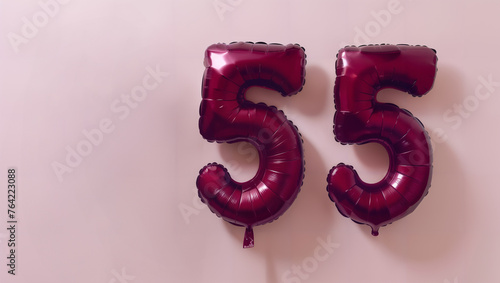 Birthday card/background for the 55th birthday in the form of two bordeaux balloons on a pink background for custom text. photo