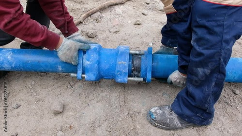 Workers installing water supply pipeline system, close up