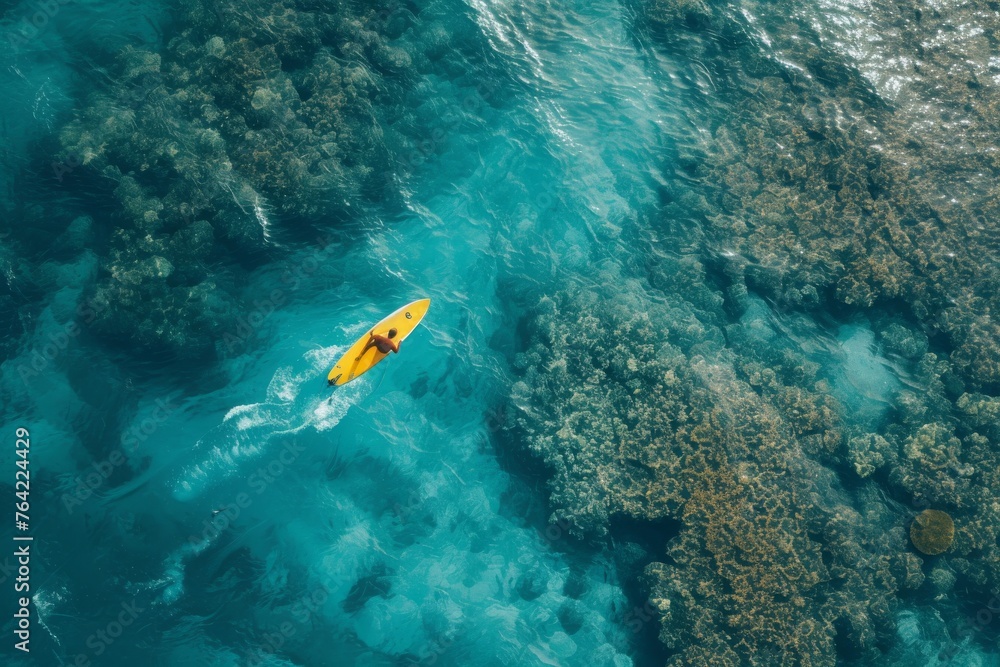 An overhead image showcasing a yellow kayak floating on the open ocean, Bird's-eye view of a surfer riding in a clear, coral-filled sea, AI Generated An overhead image showcasing a yellow kayak floating on the open ocean, Bird's-eye view of a surfer riding in a clear, coral-filled sea, AI Generated