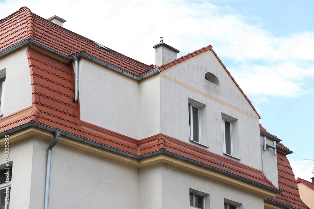 The roof of the house is made of red tiles. Angular roof.