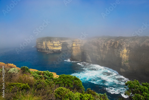 As the morning fog dissipates, the eroded limestone cliffs of the rugged south coast of Australia come into view. photo