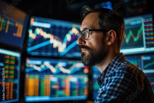 Man With Glasses and Beard Standing in Front of Multiple Monitors, Confident man surrounded by screens displaying real-time stocks in a trading room, AI Generated