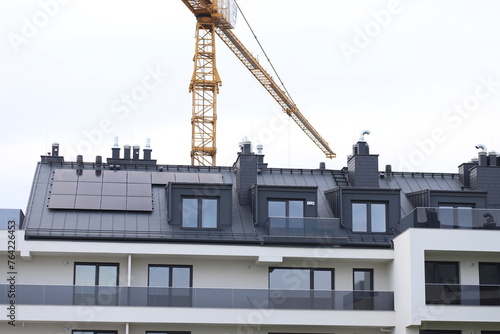 A high-altitude crane over a new house. Construction of a new residential building. Elite housing complex.
