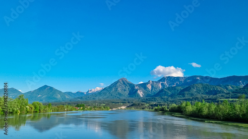 Drava river with panoramic view of majestic mountain ridges of Karawanks and Julian Alps, Carinthia, Austria, Europe. Idyllic landscape in Austrian Alps. Natural wilderness in summer. Wanderlust
