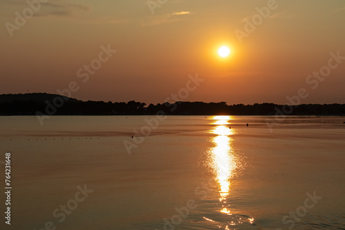 Beautiful sunset at beach in coastal town Medulin, Istria peninsula, Croatia, Europe. Romantic view of idyllic coastline of Kvarner Gulf in Adriatic Mediterranean Sea in tranquil summer. Tranquility