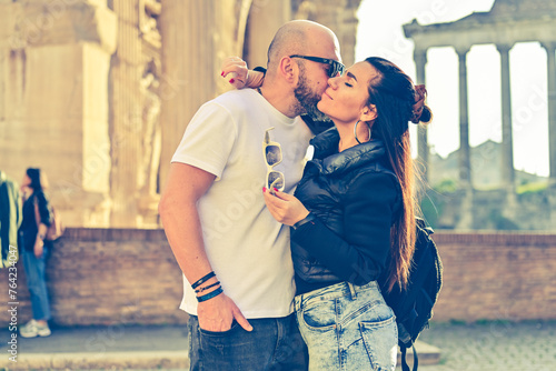 Happy  Beautiful smiling Tourists  couple traveling together on romantic travel vacation holiday in Europe. Visiting italian famous landmarks at Rome.Hugging near a  bridge on Tiber river