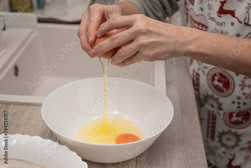 Billede på lærred Hands cracking eggs in a bowl