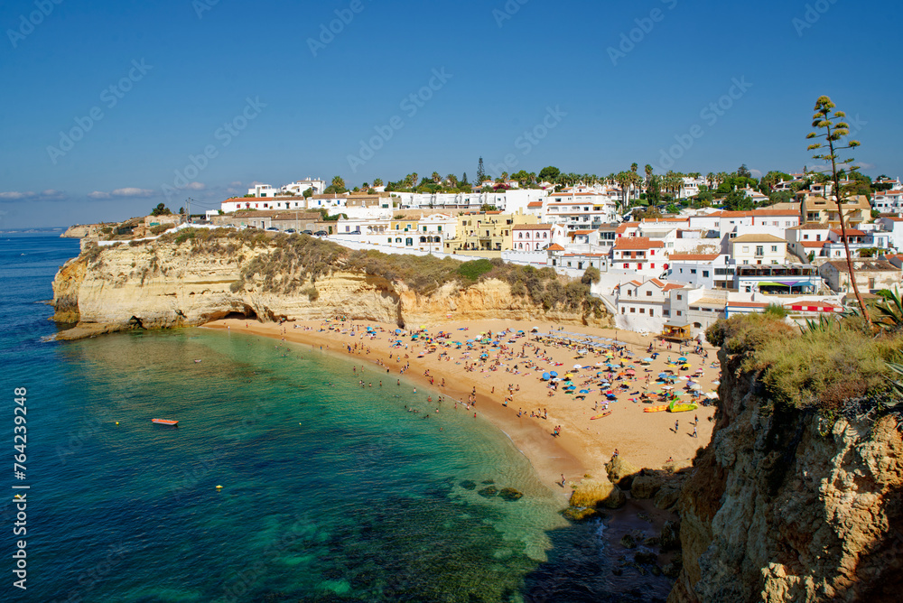 People on the Carvoeiro beach in Algarve, Portugal during a summer day. Summer holidays and vacations on the Atlantic Ocean.