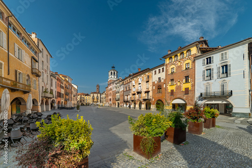 Savigliano, Cuneo, Piedmont, Italy - March 21, 2024: Piazza Santarosa with the civic tower, main coble stone square with historic buildings of medieval origin with arcades