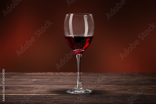 Red wine in glass on wooden desk