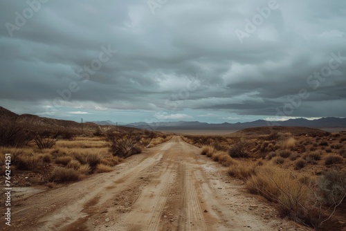 A road in the desert with a cloudy sky above