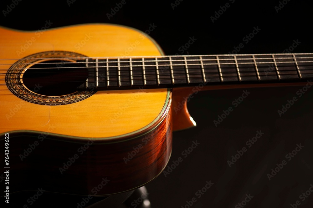 Classical Spanish flamenco guitar close up, dramatically lit isolated on black background with copy space. Classical Spanish flamenco guitar close up, dramatically lit isolated on black background with copy space.