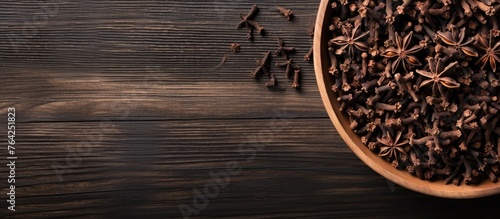 Bowl filled with cloves on wooden table