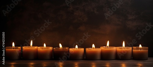 Burning candles in a line on wooden surface