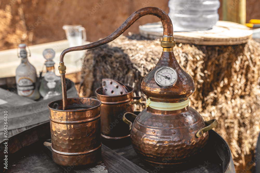 Artisan distillation: the timeless craft of a copper alembic still poised atop an aged wooden barrel Artisan distillation: the timeless craft of a copper alembic still poised atop an aged wooden barrel
