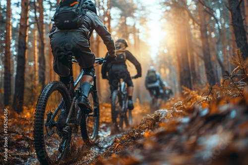 Adventure-seeking mountain bikers ride in line on a forest trail, showcasing the beauty of autumn and the joy of outdoor sports activities