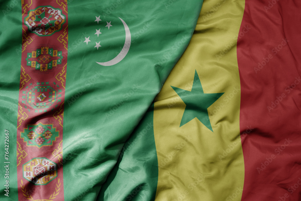 big waving national colorful flag of senegal and national flag of turkmenistan.