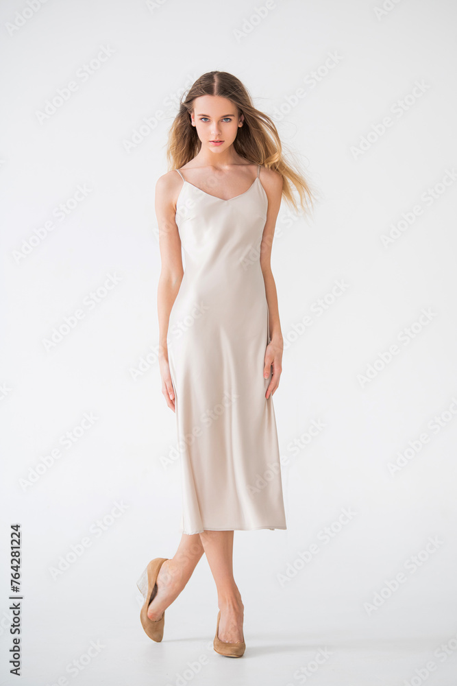 A woman in a white dress poses for the camera. A woman in a white dress poses for the camera.