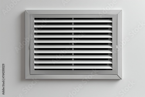 Detailed view of a vent on a wall, showing the metal grille and surrounding surface.