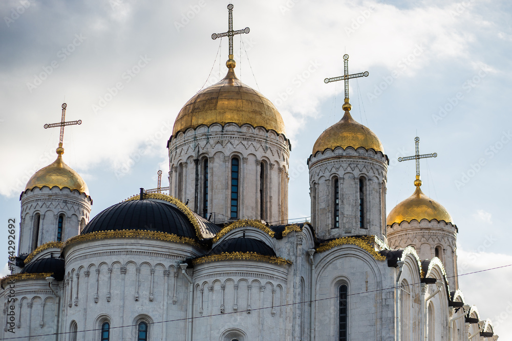 Medieval church with gold domes under cloudy sky in Byzantine architecture