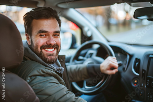 Happy Man Driving a Modern Car. A cheerful man with a beard smiling while driving, enjoying his ride in a contemporary vehicle interior.