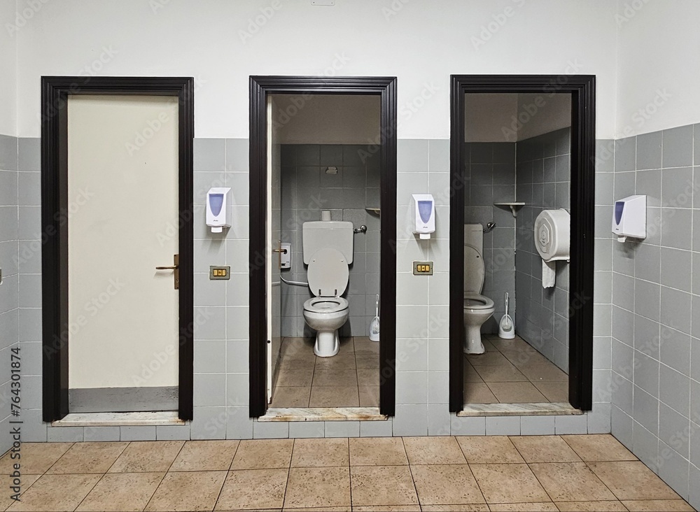 three public toilets, three doors adjacent to three toilets in a workplace to carry out one's physiological needs three public toilets, three doors adjacent to three toilets in a workplace to carry out one's physiological needs