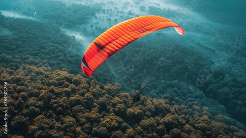 Person Parasailing Over Lush Green Forest