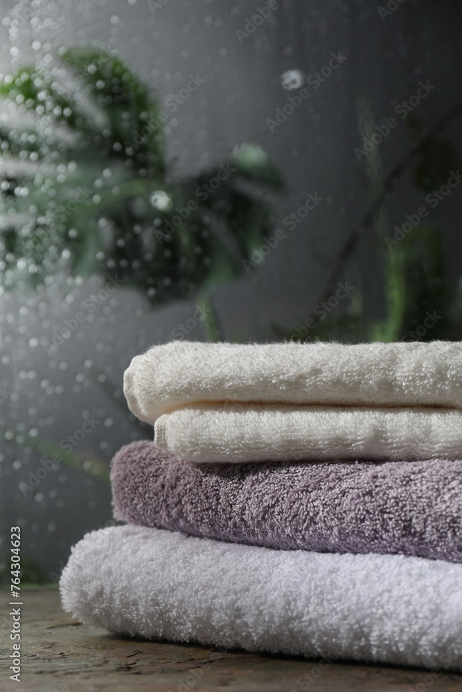 Stacked terry towels on table in bathroom - obrazy, fototapety, plakaty 