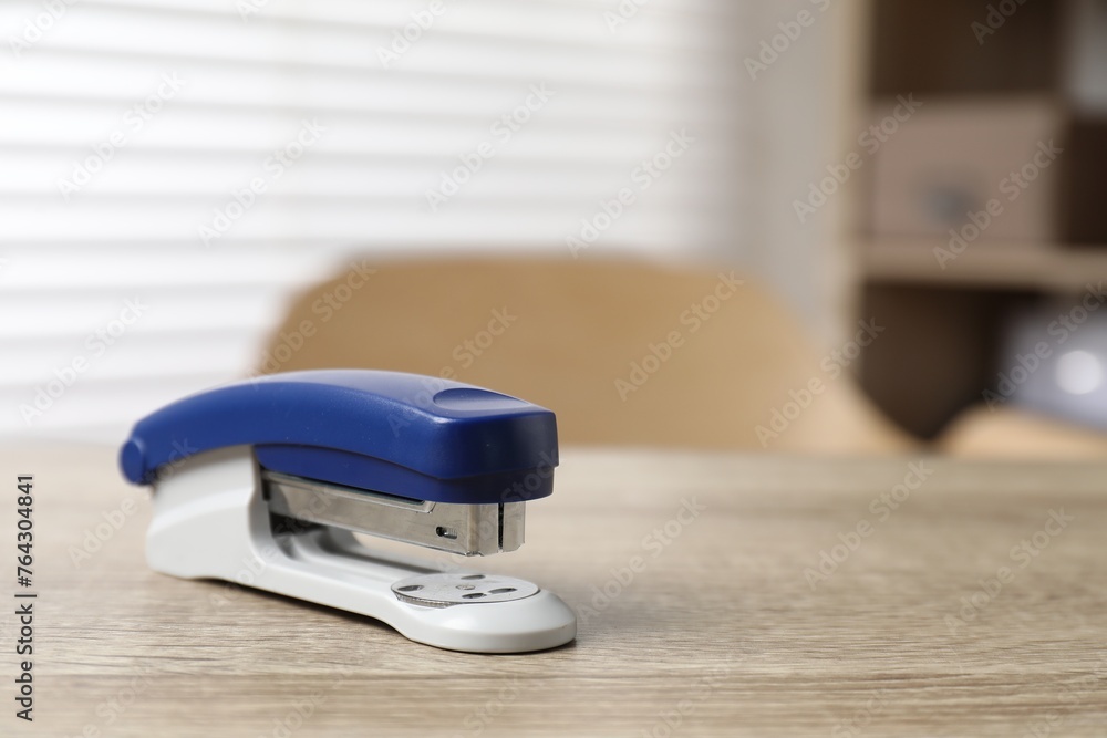 Bright stapler on wooden table indoors, closeup. Space for text Bright stapler on wooden table indoors, closeup. Space for text