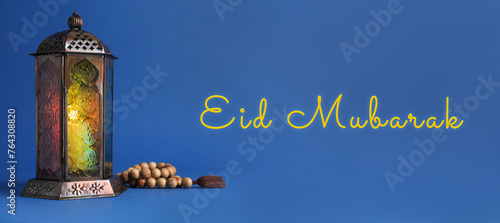 Eid Mubarak banner. Arabic lantern and misbaha on blue background