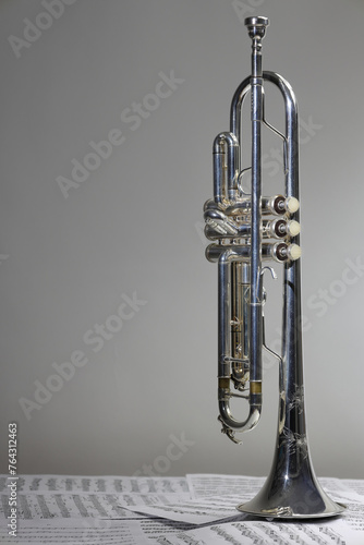 A view of the musical instrument which is the trumpet against the background of the sheet music