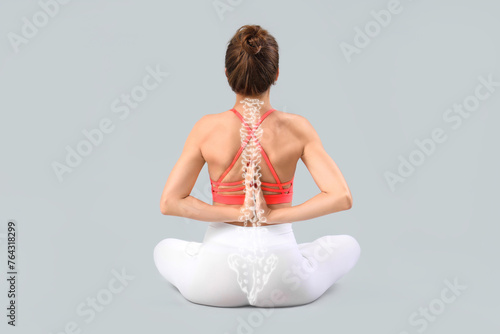Young woman doing yoga on g...