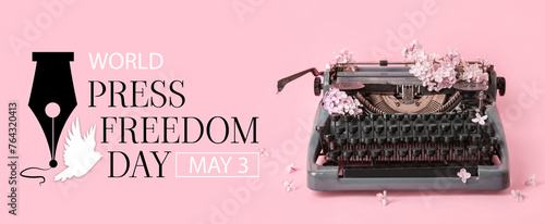 Vintage typewriter with lilac flowers on pink background