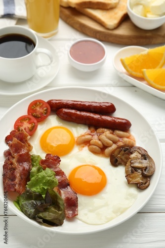 Delicious breakfast with sunny side up eggs on white wooden table