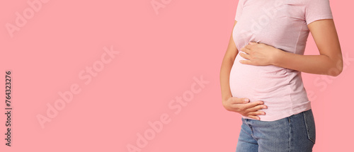 Young pregnant woman on pink background with space for text, closeup