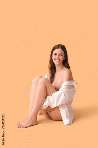 Body positive woman sitting on beige background