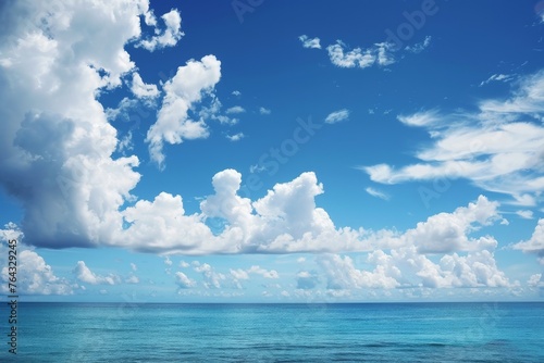 The image captures a tranquil ocean as it meets the sky, dotted with fluffy, white clouds and offering a sense of calm © ChaoticMind