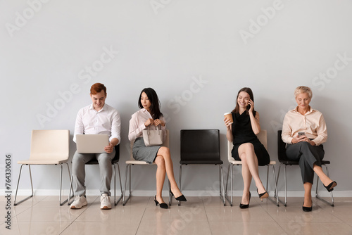 Applicants waiting for job interview near light wall photo
