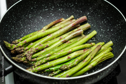 A pan of asparagus is cooking on a stove
