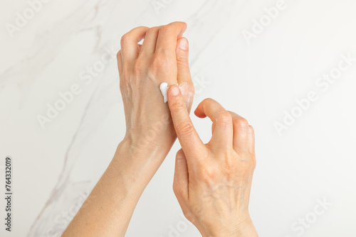 Woman applying cream on their hands © Olena