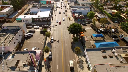 Aerial: Drone Backward Shot Of Cars Moving On Road Amidst Buildings In Residential City - West Hollywood, California photo