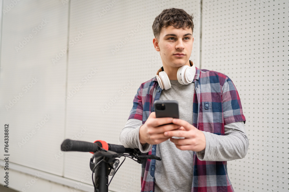 Young man caucasian teenager with electric kick push scooter in city Young man caucasian teenager with electric kick push scooter in city