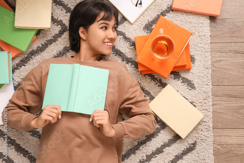 Young woman reading book on...