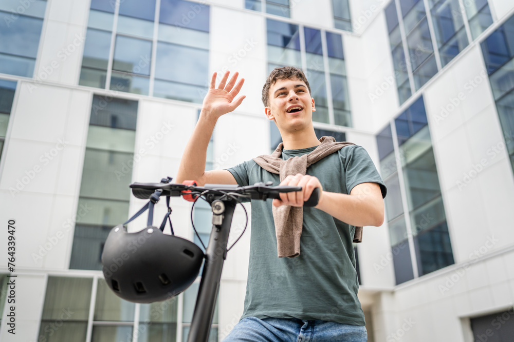 Young man caucasian teenager with electric kick push scooter in city Young man caucasian teenager with electric kick push scooter in city