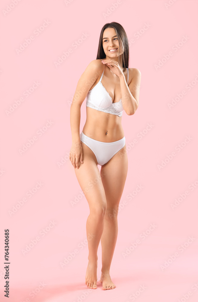 Slim young woman in white underwear on pink background Slim young woman in white underwear on pink background