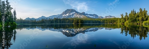Mountain in morning light reflected in calm waters of lake. Nature landscape panorama on a sunny day.