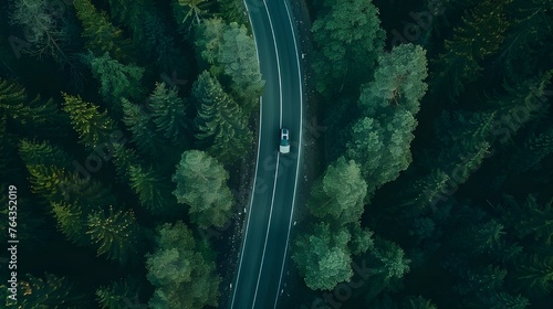 Aerial view green forest with car on the asphalt road, Car drive on the road in the middle of forest trees. © Penatic Studio