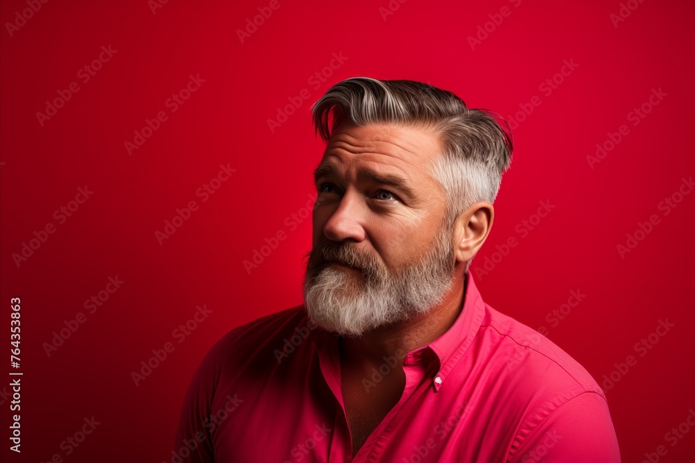 Portrait of a handsome mature man on a red background. Men's beauty, fashion.
